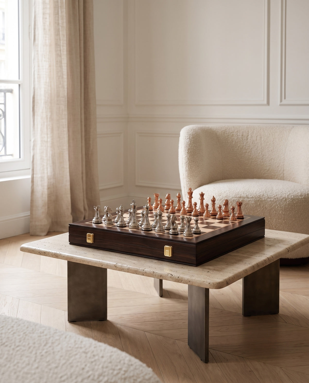 The Regent folding chess set with electroplated pieces on a travertine table
