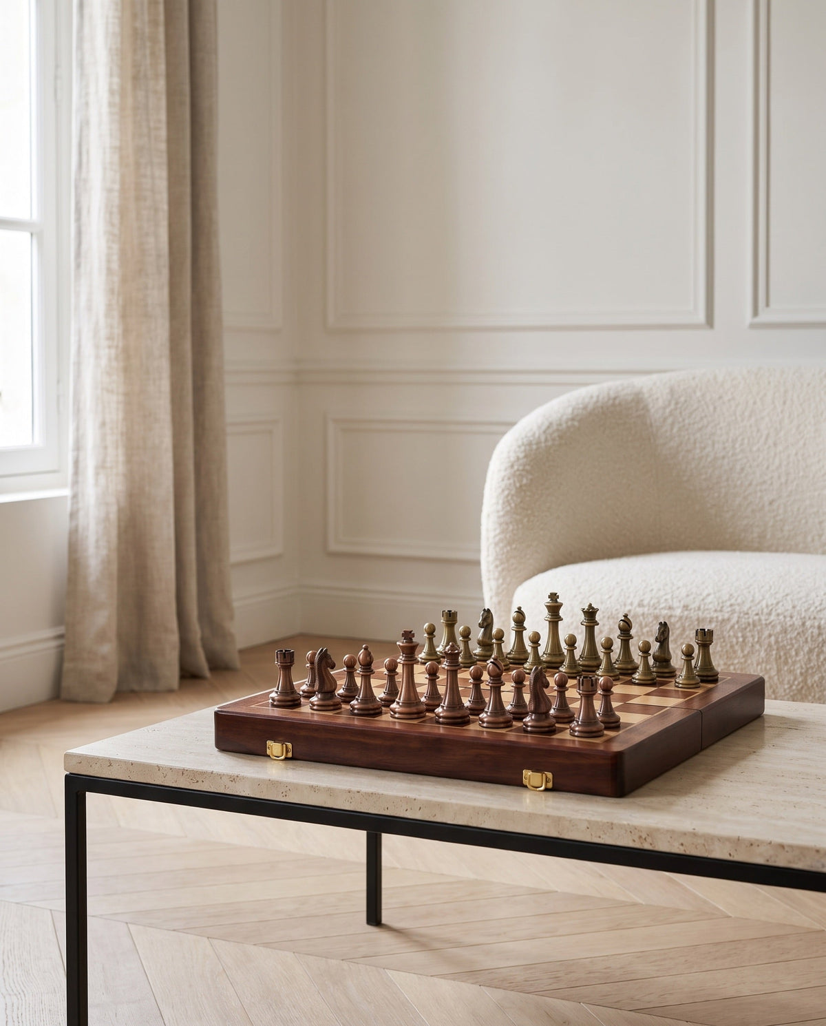 The Consul folding walnut chess set with metal pieces on a travertine table