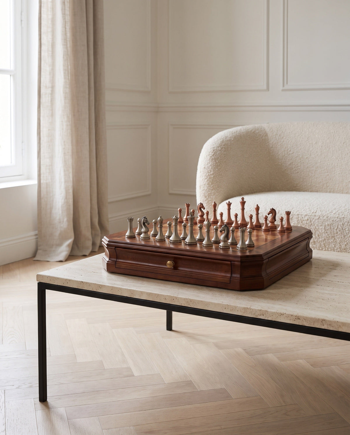 The Sovereign mahogany chess set with metal pieces on a travertine table