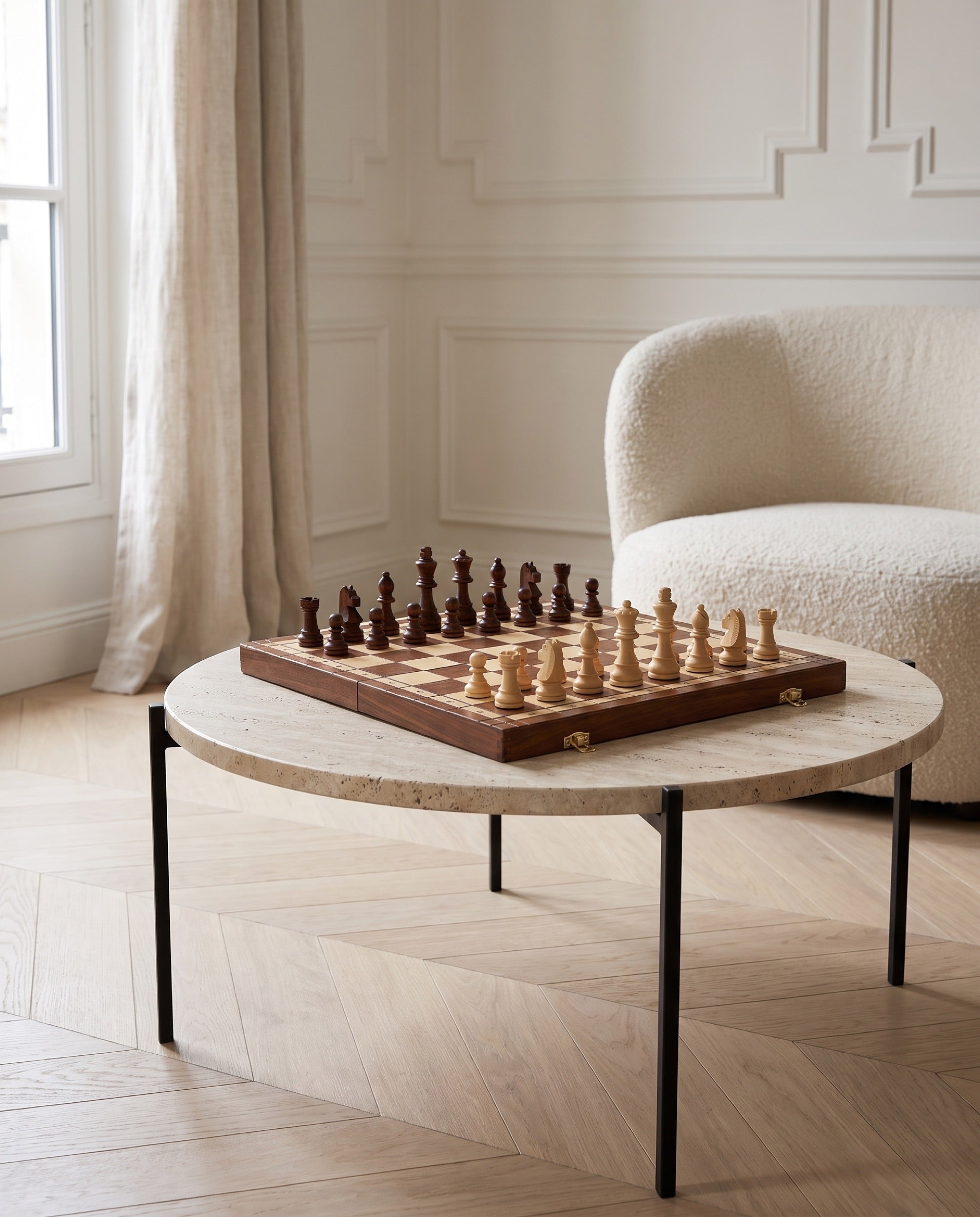 The Voyager folding walnut chess set on a travertine table